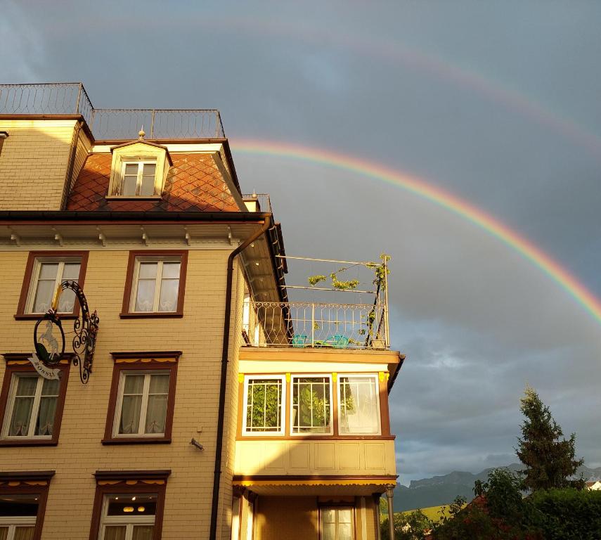 einen Regenbogen am Himmel über einem Haus in der Unterkunft B&B Gästehaus Rössli Schwellbrunn in Schwellbrunn