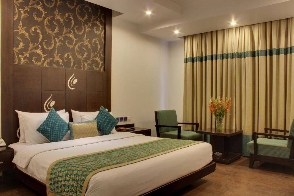 a hotel room with a bed and a chair at Hotel Godwin Deluxe -Near New Delhi Railway Station - Paharganj in New Delhi