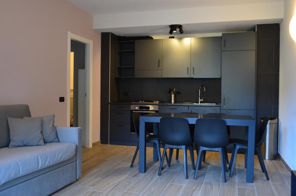 kuchnia i salon z niebieskim stołem i krzesłami w obiekcie Appartamenti Sky Express w mieście Campodolcino