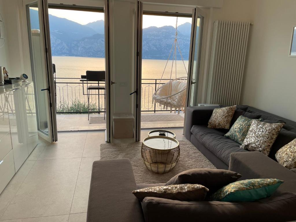 a living room with a couch and a view of the ocean at Ferienwohnung Malcesine ,Val di Sogno - Gardasee Italien in Malcesine