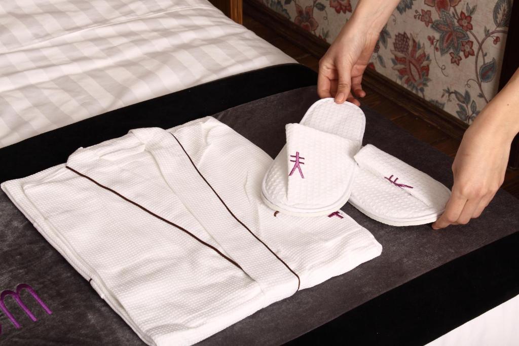 una persona está poniendo calcetines blancos en una cama en Sleepy Tom Boutique Hotel en Moscú