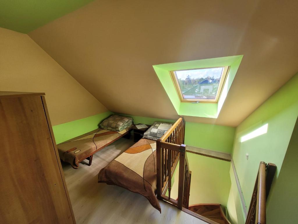 a attic room with two bunk beds and a window at Dom gościnny Monika in Pobierowo