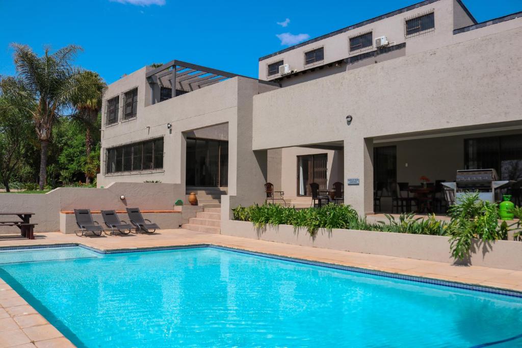 a house with a swimming pool in front of a house at Fair Glen in Kyalami