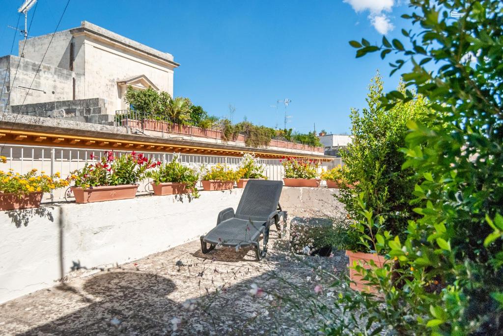 uma cadeira preta sentada ao lado de um edifício em Il Garbino Suite and Apartment em Lecce