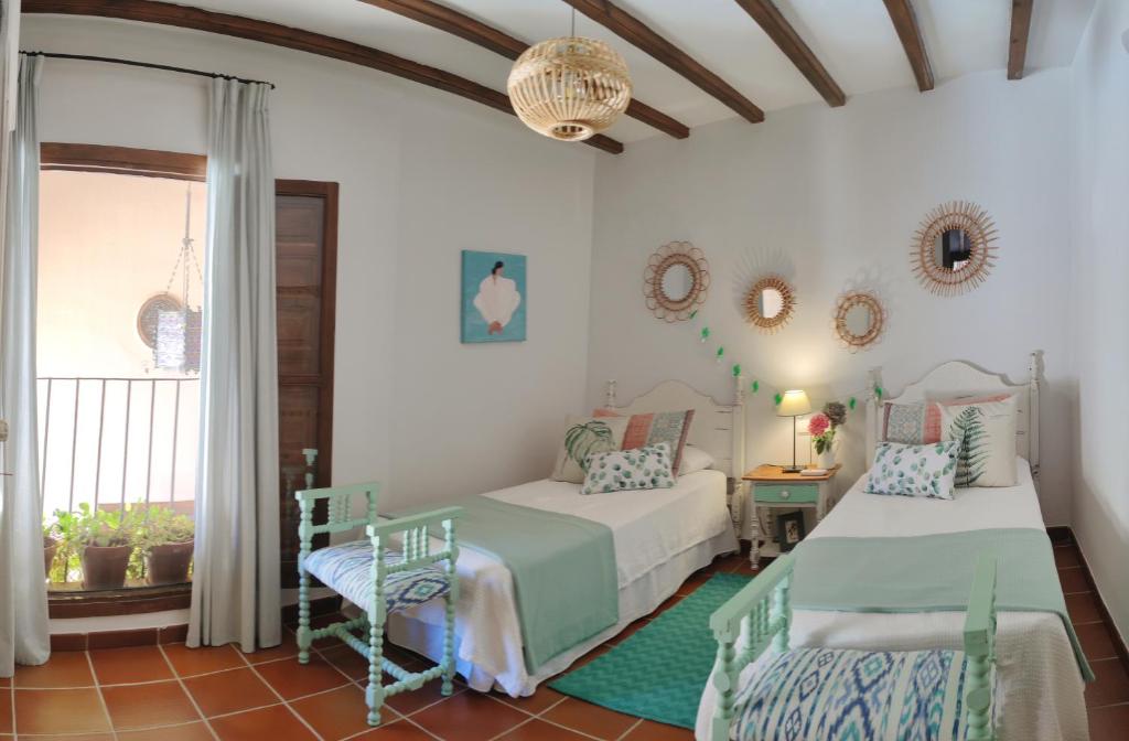 a bedroom with two beds and a window at Masía de San Juan, casa rural renovada en Castillo con piscina y Aire Acondicionado in Segorbe
