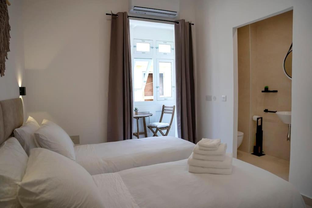 Habitación de hotel con 2 camas y baño en The Olive 3 - Traditional Maltese Accommodation, en Birgu