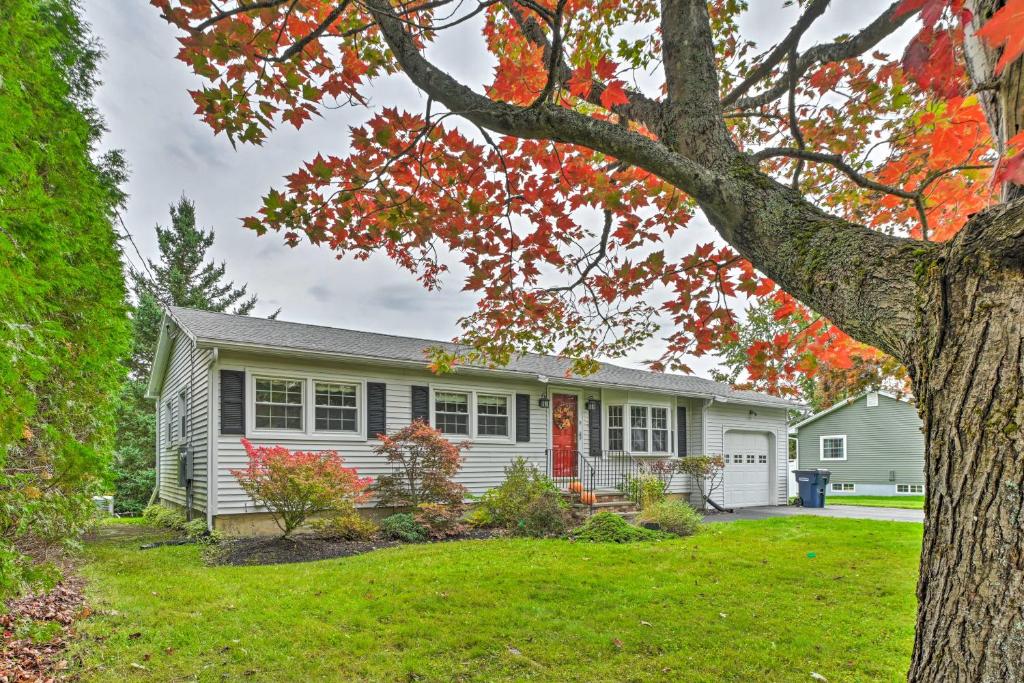 una casa blanca con un árbol en el patio en Cottage 3 Miles to Dwntwn and Bangor Waterfront 