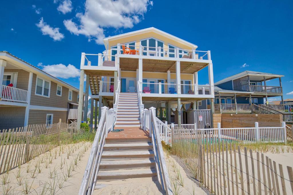 a house on the beach with a white fence at Boundless Horizons in Surf City
