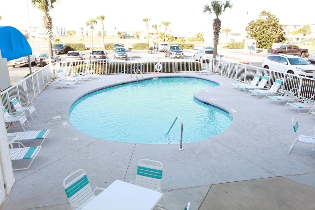 une grande piscine avec des chaises et une clôture dans l'établissement Island Sunrise 563, à Gulf Shores