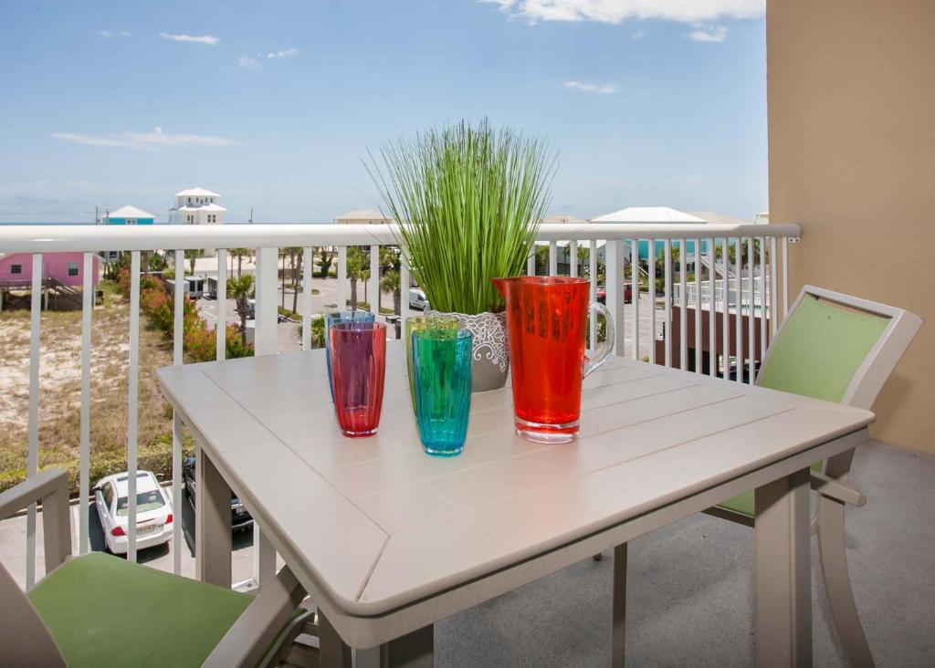 cuatro jarrones coloridos sentados en una mesa en un balcón en Sanibel 307, en Gulf Shores