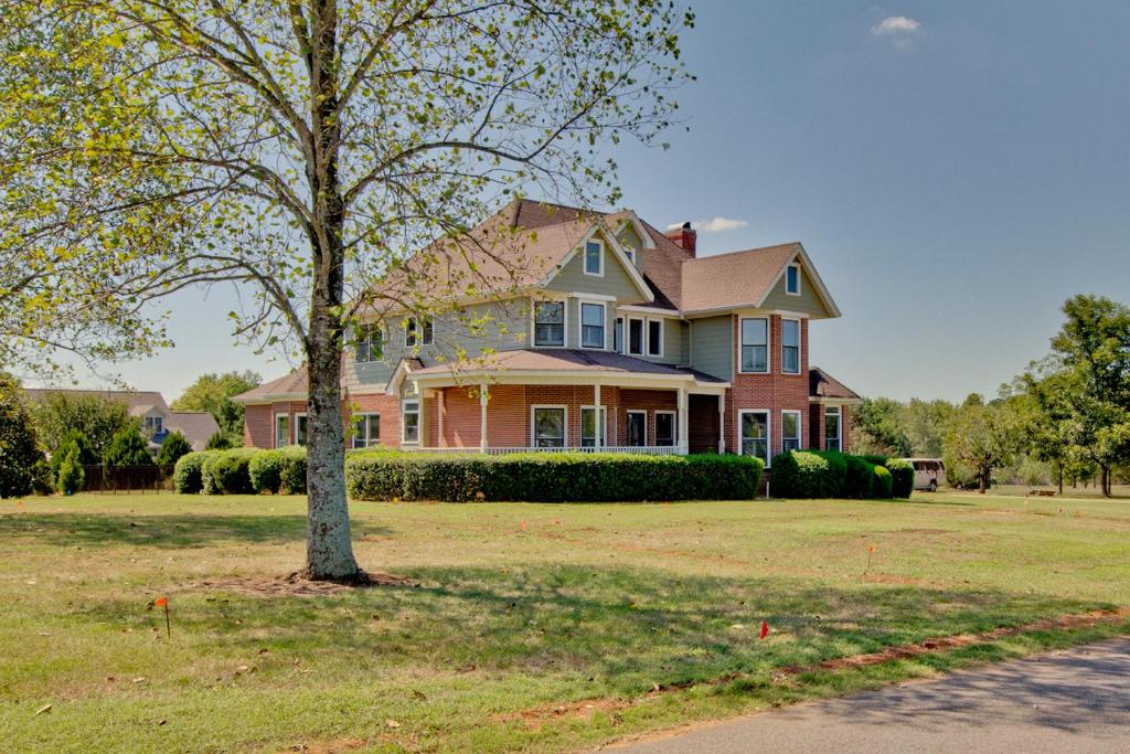 een groot huis met een boom in de tuin bij Apperson House in Madison