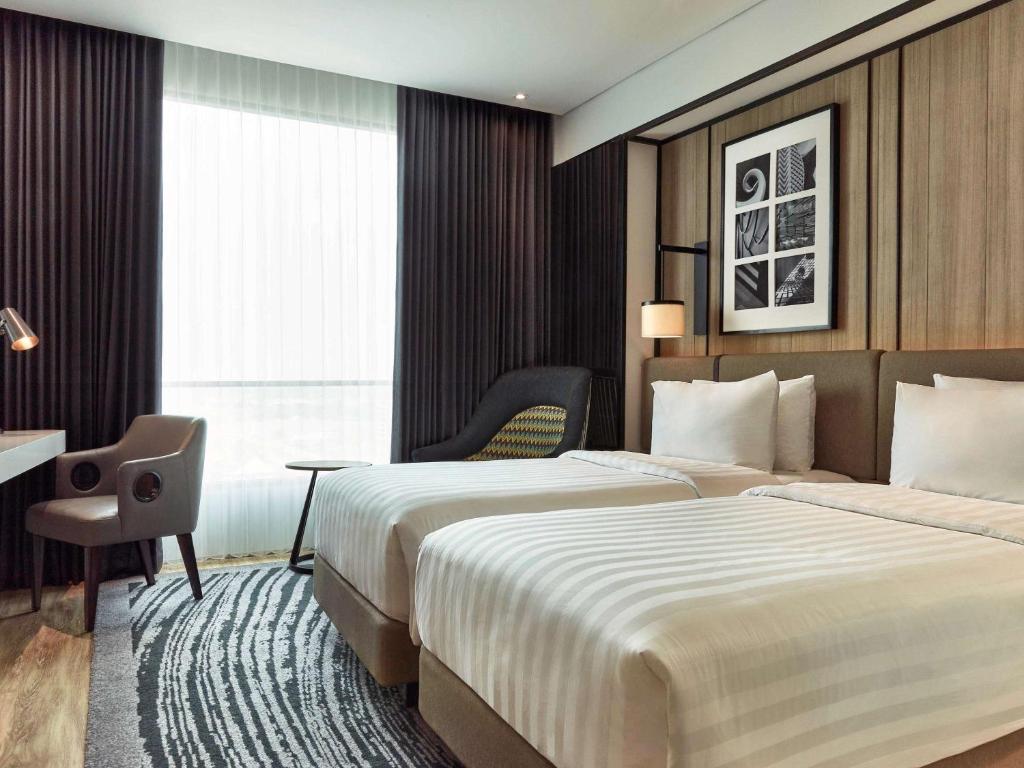 Postel nebo postele na pokoji v ubytování Novotel Karawang