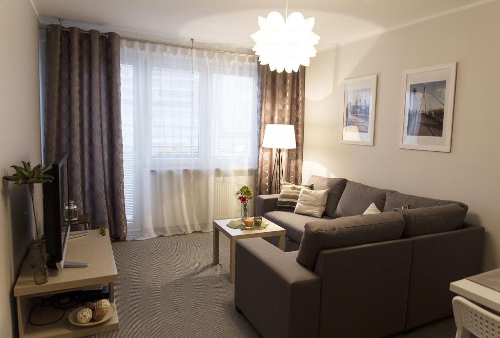 ein Wohnzimmer mit einem Sofa und einem Fenster in der Unterkunft Warsaw Budget Apartments in Warschau