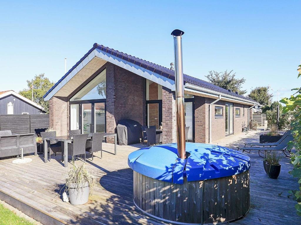 オテルプにある6 person holiday home in Otterupの木製デッキ(家の前に青い大きな噴水あり)