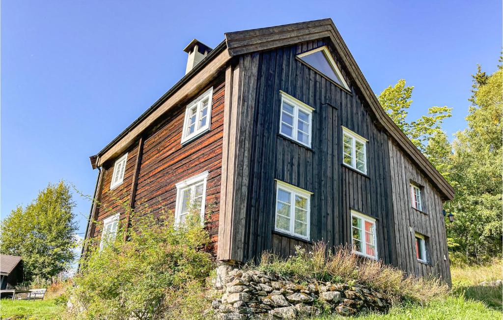 uma casa preta com um telhado de gambrel em Lovely Home In yer With House A Mountain View em Øyer