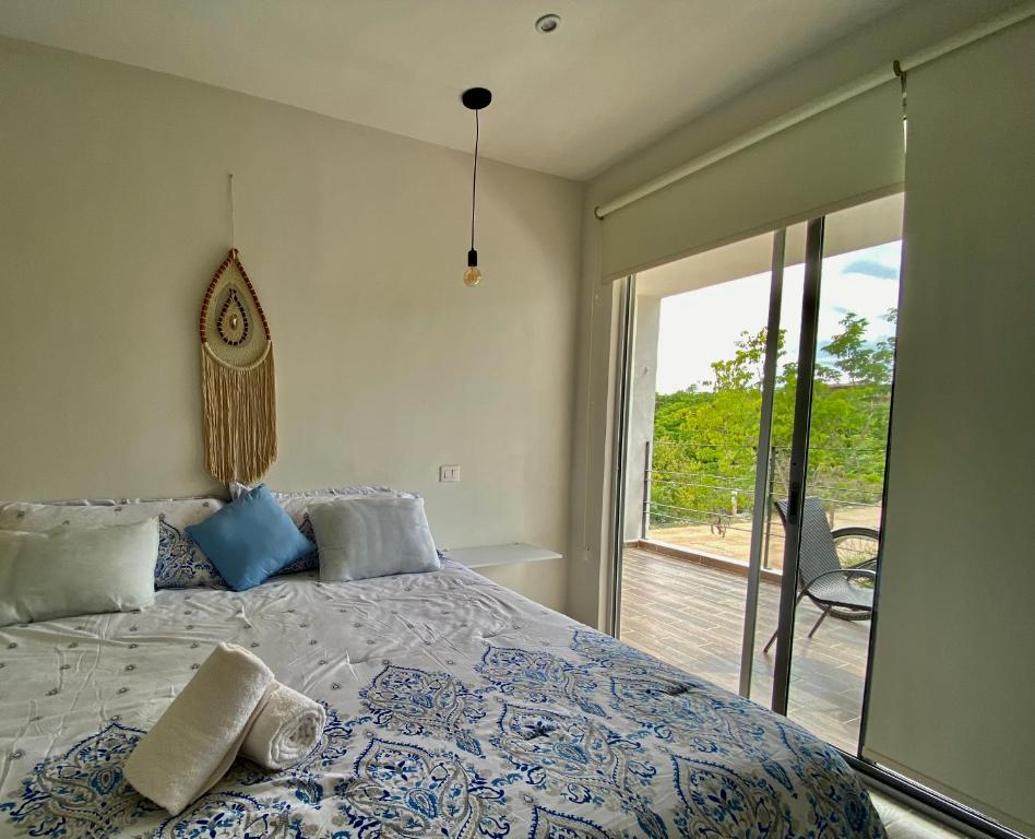 a bedroom with a bed with a view of a deck at Rosa Azul Tulum in Tulum