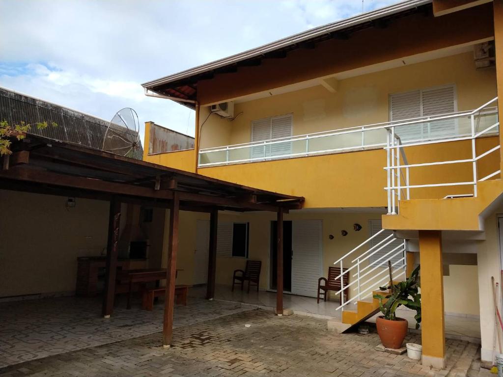a yellow building with stairs and a balcony at Casa espaçosa 3 dorms no Centro de Bombinhas in Bombinhas