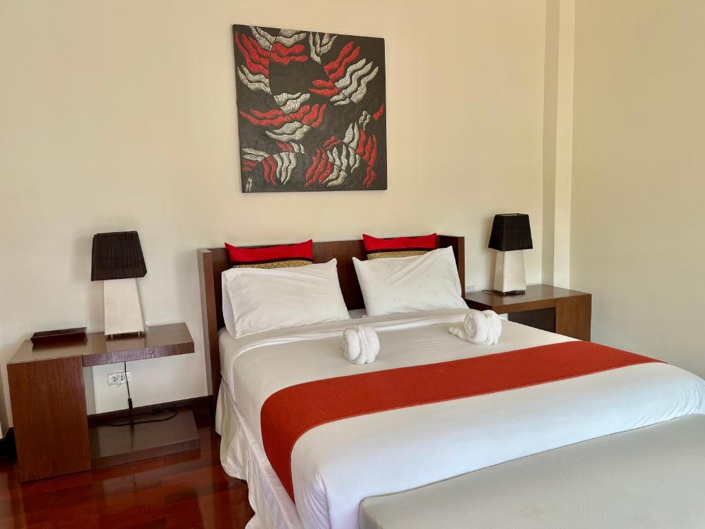 a bedroom with a large bed with red and white sheets at Villa Nirwana - Jasmin 3BR with private pool in Ban Ang Thong