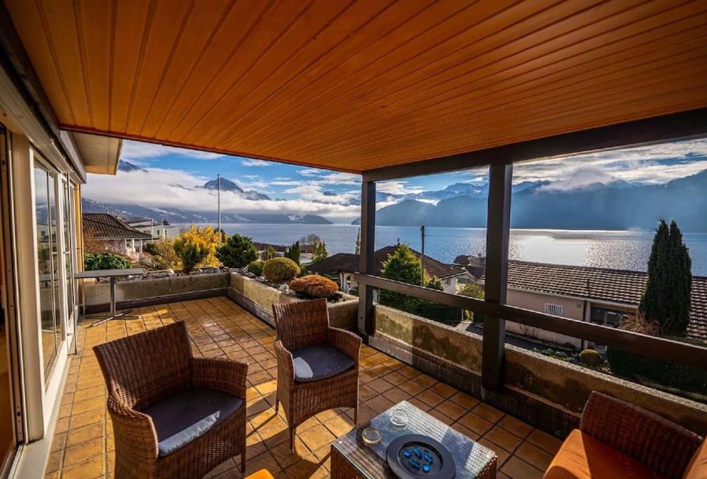 a patio with two chairs and a table on a balcony at Swiss Paradise Weggis in Weggis