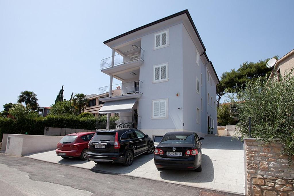 deux voitures garées devant un bâtiment dans l'établissement Apartments with a parking space Rovinj - 3393, à Rovinj