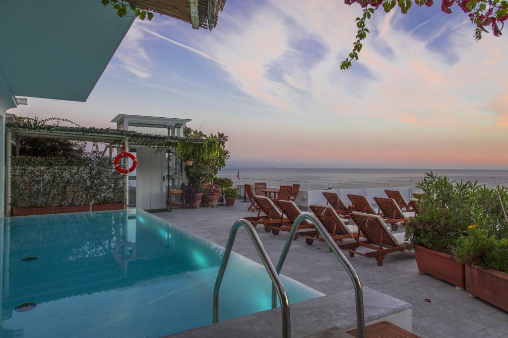 una piscina con sillas y vistas a la playa en Hotel Marina Riviera, en Amalfi