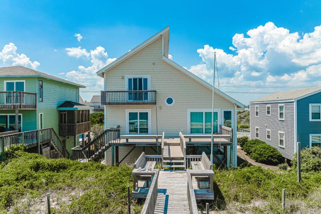 a house with a boardwalk leading to a house at Slow Your Roll in Topsail Beach