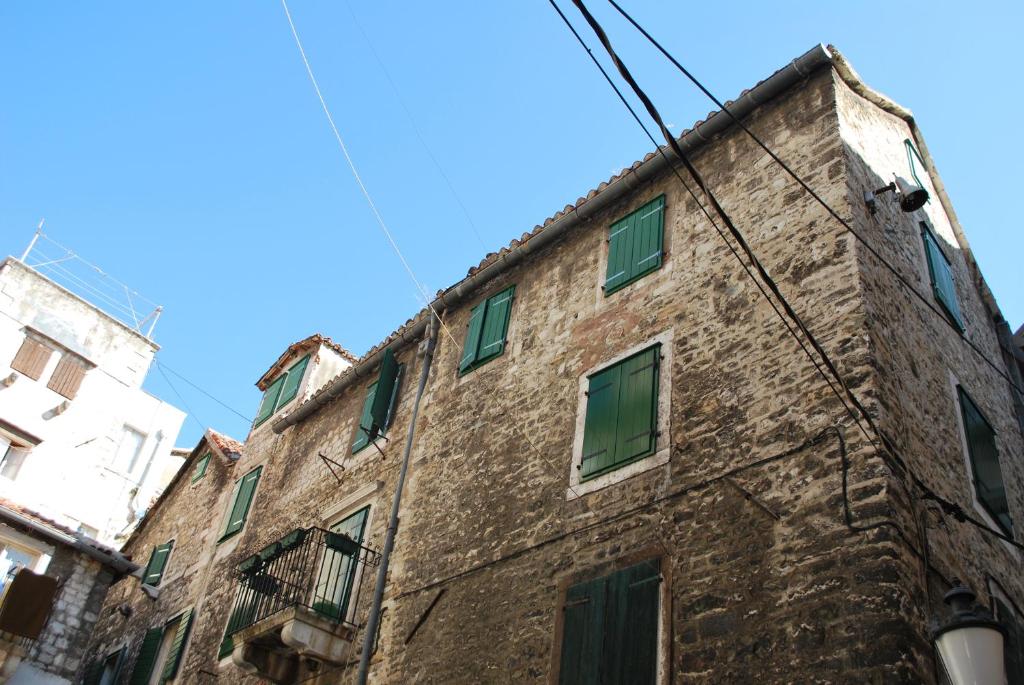 un antiguo edificio de ladrillo con ventanas verdes en Apartments with WiFi Split - 8672 en Split