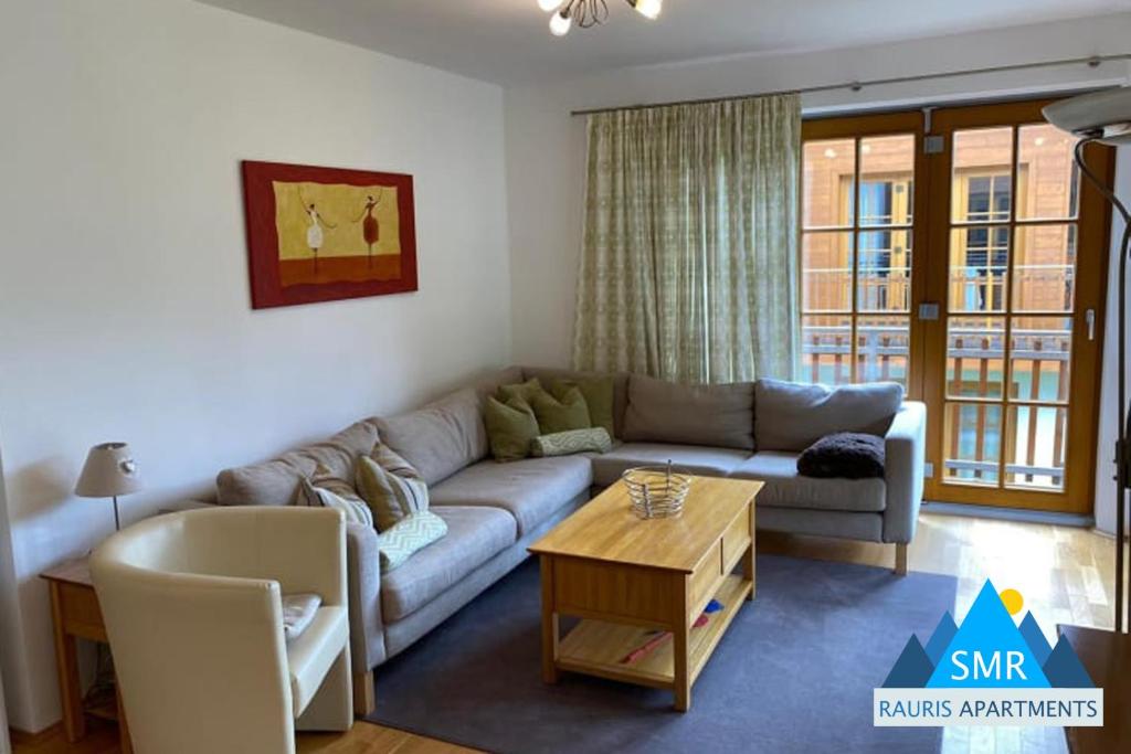 sala de estar con sofá y mesa en Isabella 4 by SMR Rauris Apartments - inc Spa and National Summercard - near Gondola, en Rauris