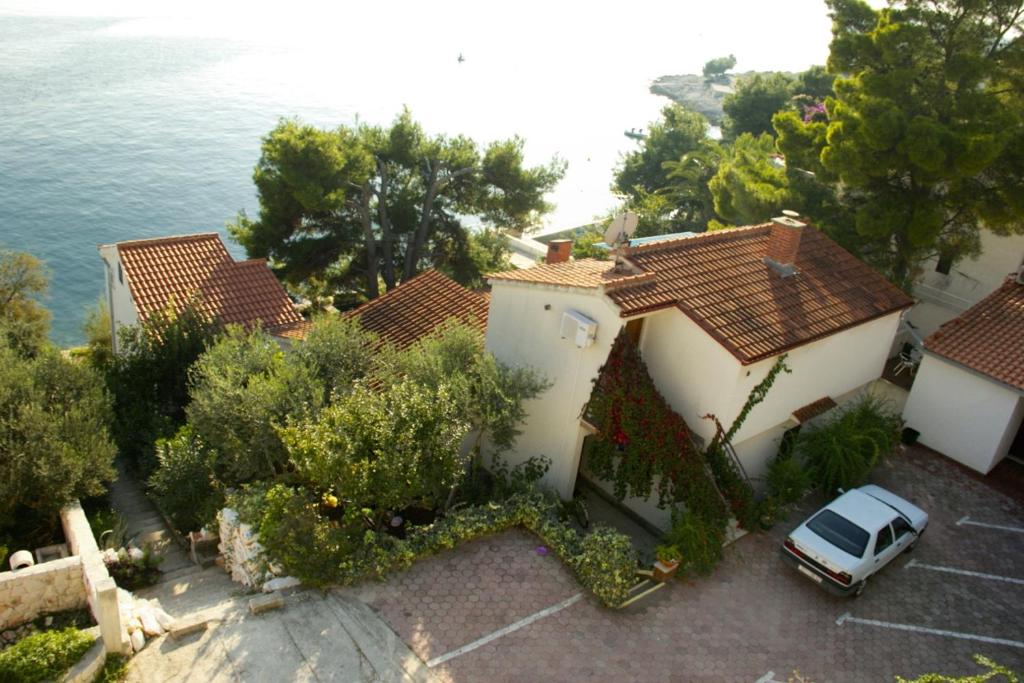 un coche aparcado en un estacionamiento frente a una casa en Apartments by the sea Rastici, Ciovo - 8619 en Trogir