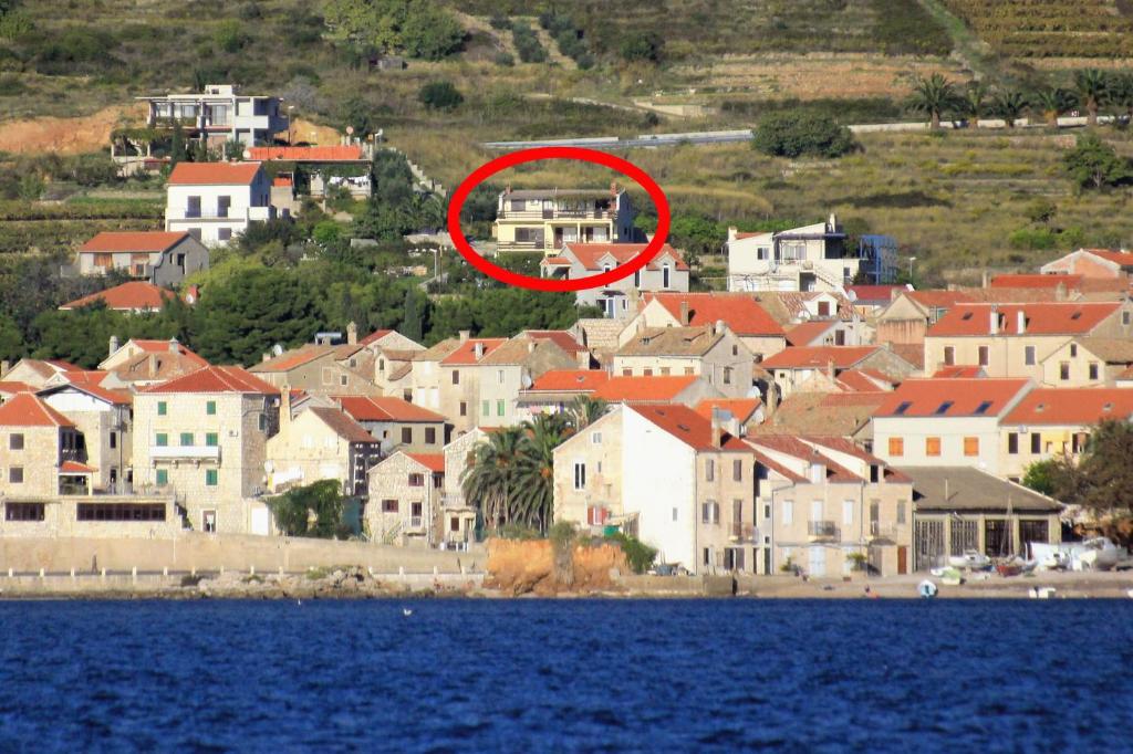 a house in the middle of a town next to the water at Studio Komiza 8844a in Komiža