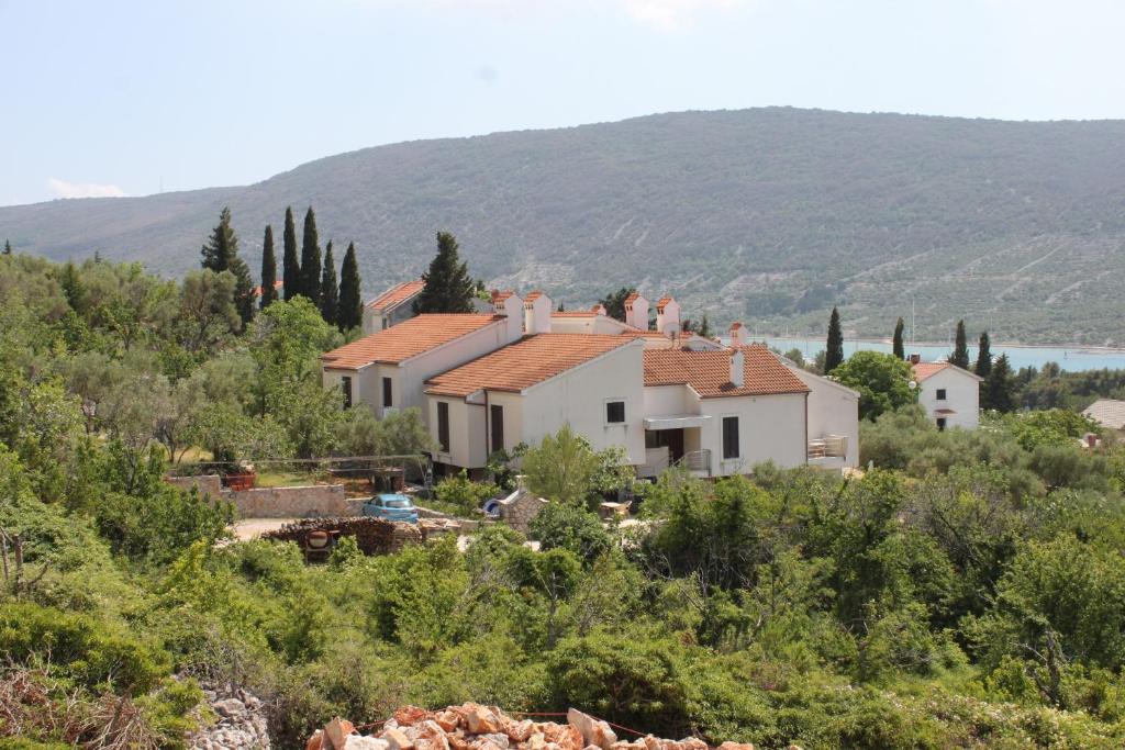 a house on top of a hill with trees at Apartments with a parking space Cres - 7876 in Cres