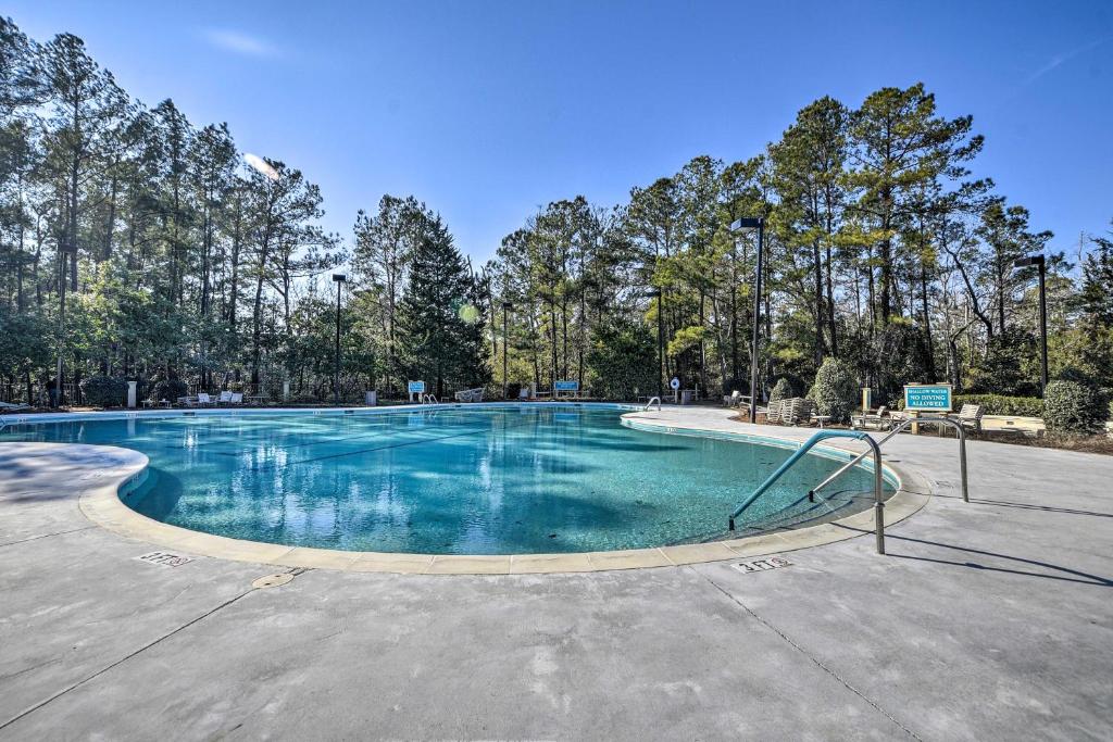 an empty swimming pool with trees in the background at Coastal Golf Resort Condo Less Than 4 Mi to Beach! in North Myrtle Beach