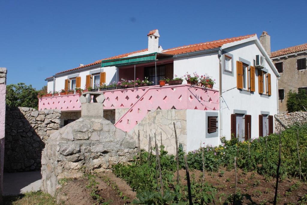 a house with a pink roof and a stone wall at Apartment Stivan 382a in Štivan