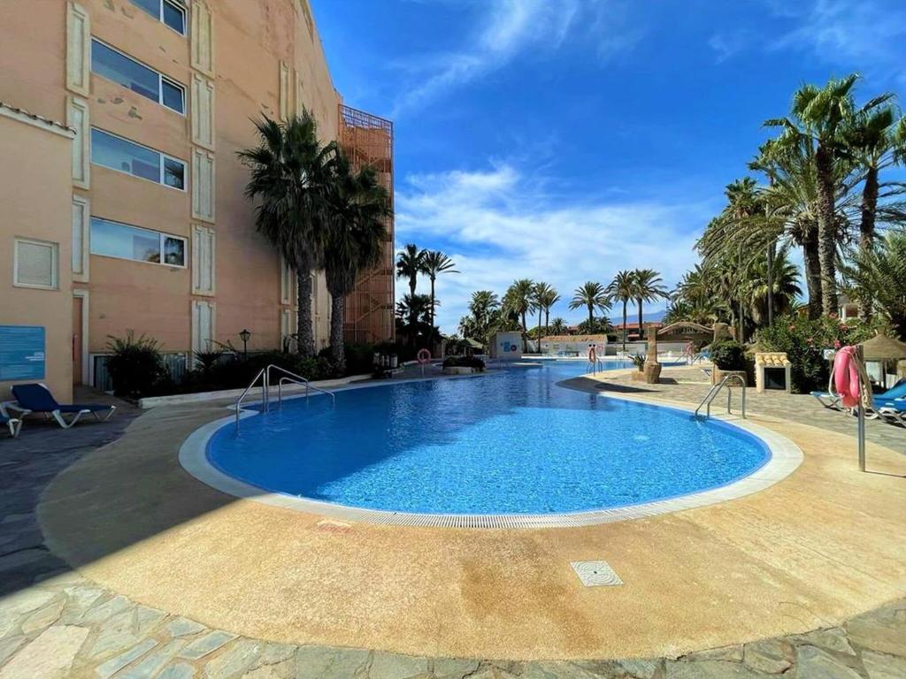 une grande piscine en face d'un bâtiment dans l'établissement Inviting holiday home in Roquetas de Mar with terrace, à Roquetas de Mar