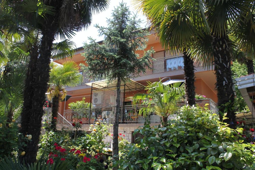 budynek z palmami i kwiatami przed nim w obiekcie Apartments with a parking space Lovran, Opatija - 2336 w mieście Lovran
