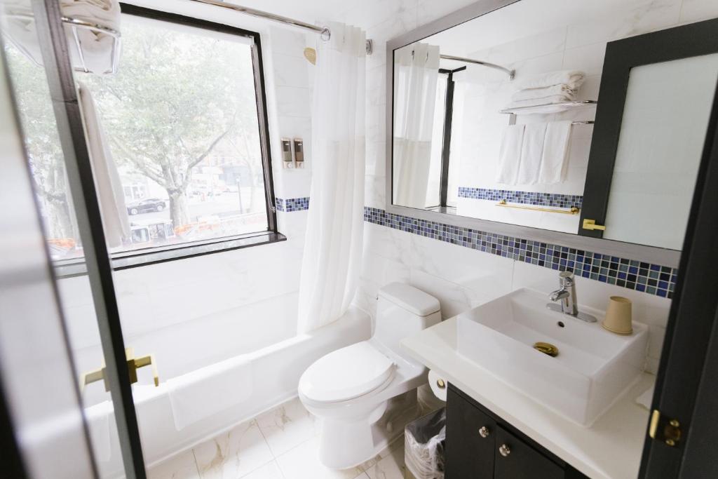 a bathroom with a sink and a toilet and a window at Hotel Richland LES in New York