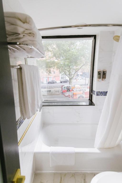 a bathroom with a window and white towels at Hotel Richland LES in New York