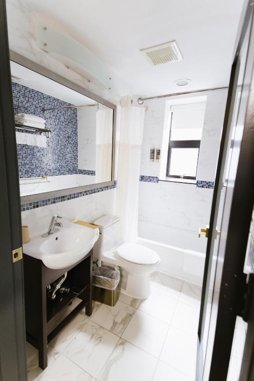 a white bathroom with a sink and a toilet at Hotel Richland LES in New York