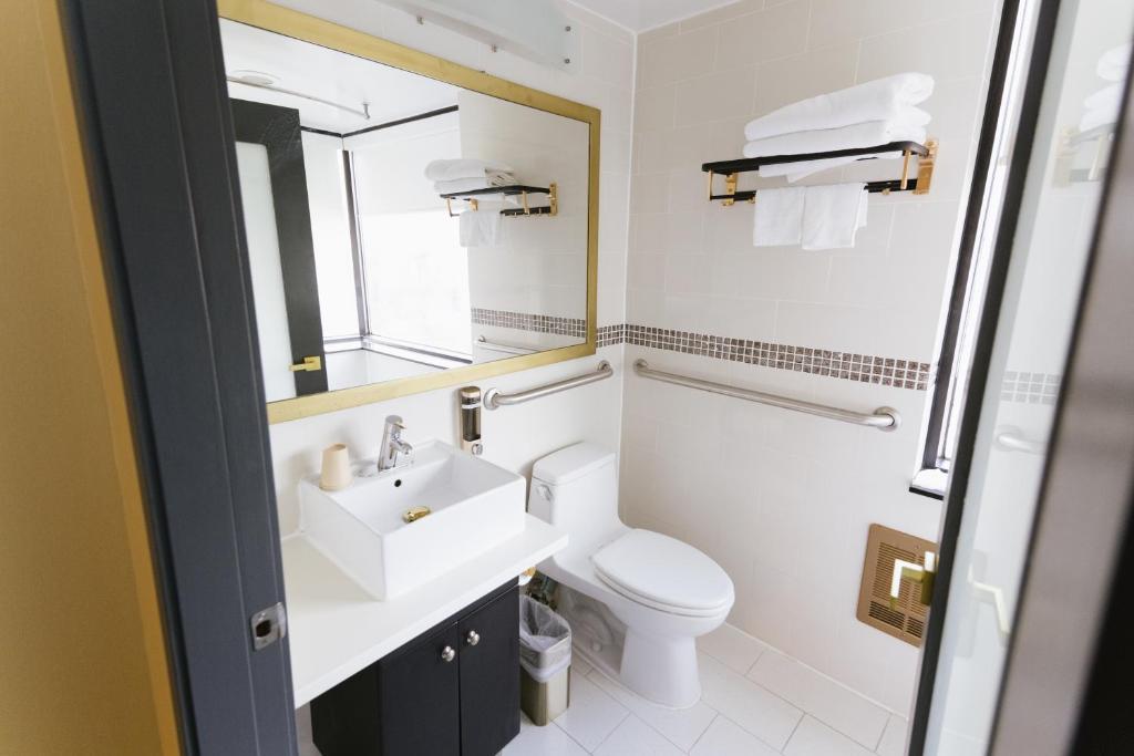 a bathroom with a sink and a toilet and a mirror at Hotel Richland LES in New York