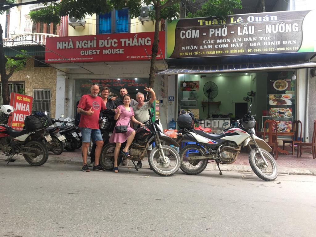 un groupe de personnes debout devant les motocycles dans l'établissement Duc Thang Guest House (Nhà Nghỉ Đức Thắng), à Diện Biên Phủ