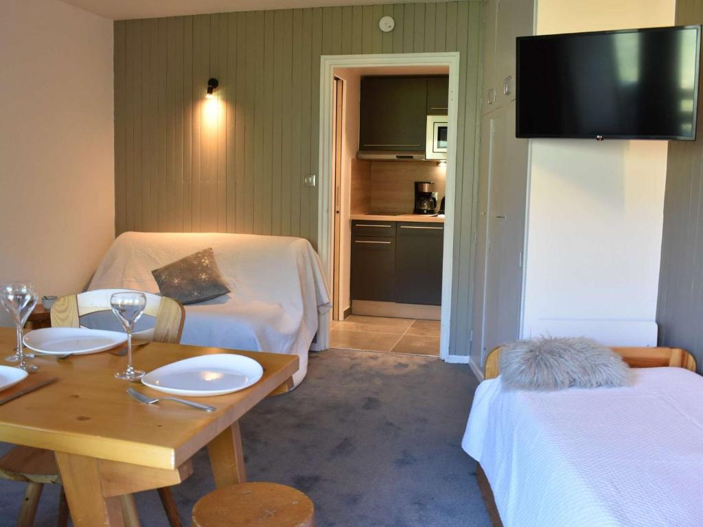 Cette chambre comprend 2 lits, une table et une télévision. dans l'établissement Studio à Méribel avec balcon et casier à ski, proche télésiège - FR-1-180-576, à Les Allues