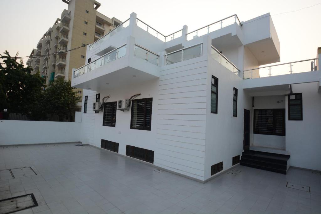 a white building with a staircase on the side at Comfort Stay in Faridabad