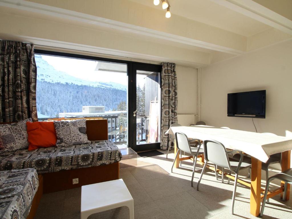 ein Wohnzimmer mit einem Sofa und einem Tisch mit Stühlen in der Unterkunft Appartement Flaine, 2 pièces, 6 personnes - FR-1-687-101 in Arâches-la-Frasse