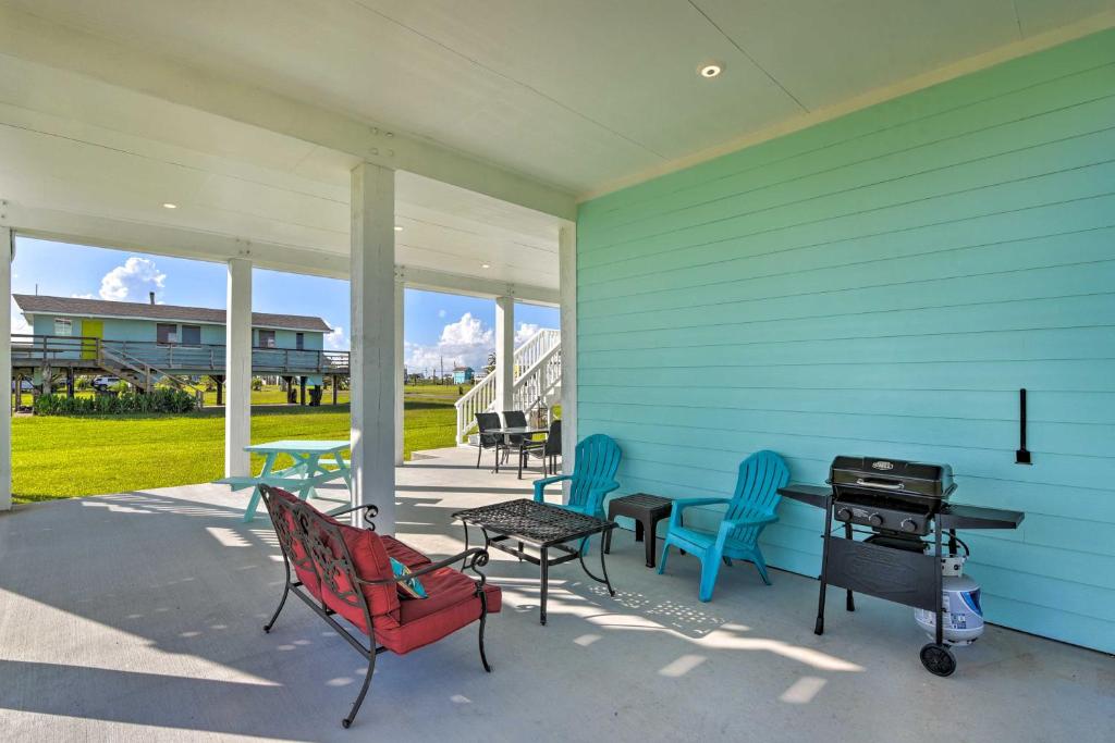 a patio with chairs and a grill on a blue house at Bright and Breezy Galveston Retreat with Deck! in Galveston
