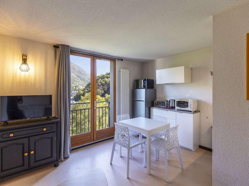 Il dispose d'un balcon et d'une cuisine avec une table et des chaises. dans l'établissement Appartement rénové T2, 4 pers., animaux admis, parking, Luz-Saint-Sauveur - FR-1-402-127, à Luz-Saint-Sauveur