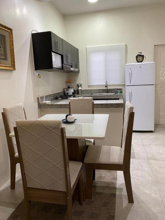 a kitchen with a table and chairs and a white refrigerator at Villa en Salinas vía Punta Carnero in Salinas