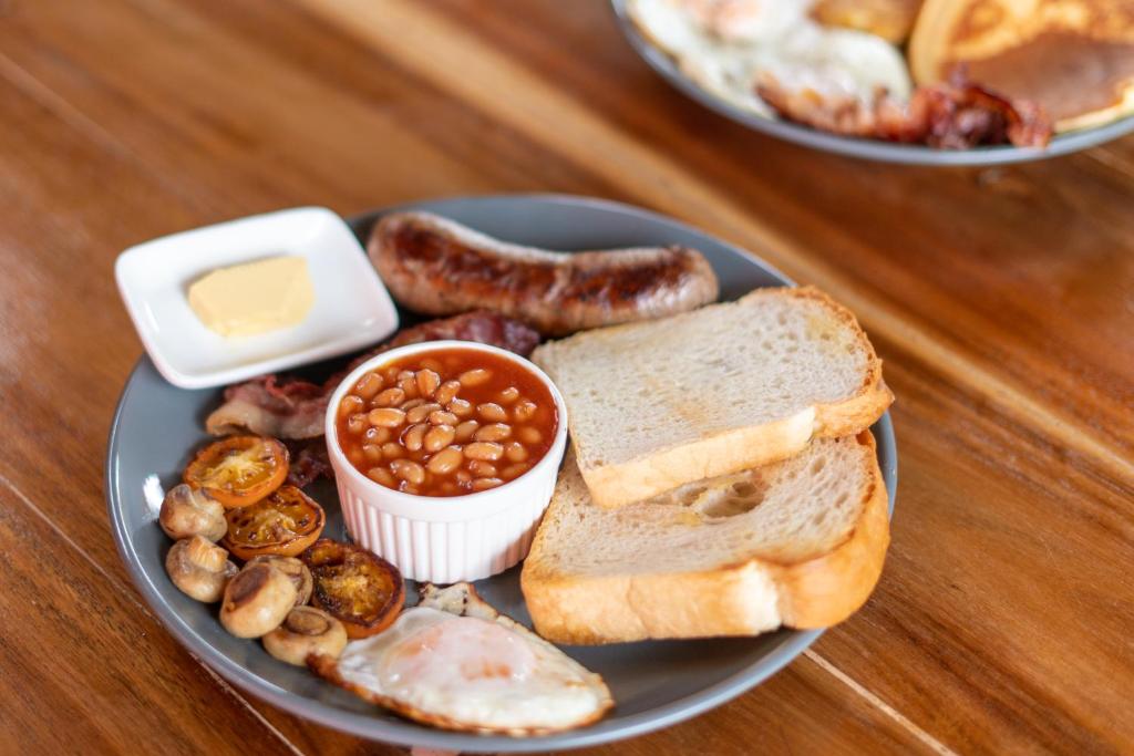 a plate of food with sausage beans beans and bread at CocoRico Hostel in San Vicente