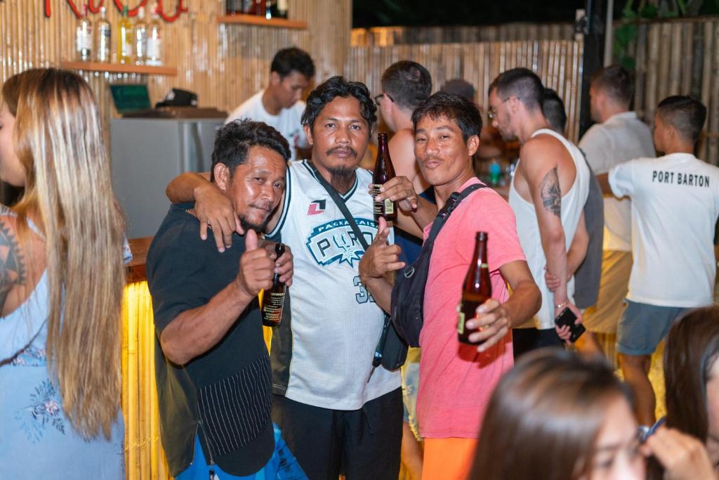 a group of people holding bottles of wine at CocoRico Hostel in San Vicente