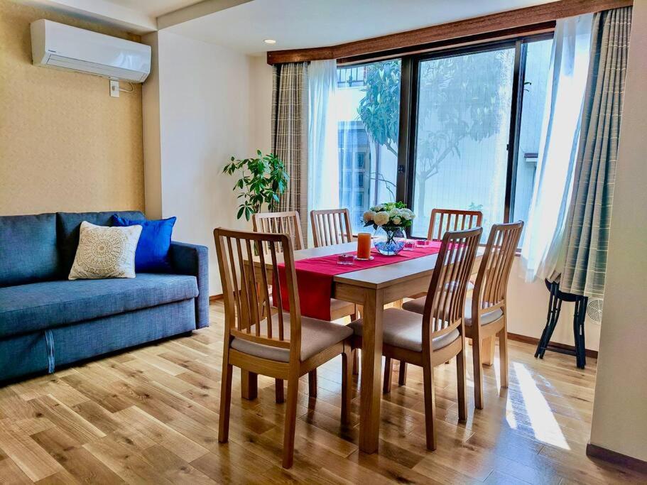 a living room with a table and chairs and a blue couch at Grato Terrace in Tokyo