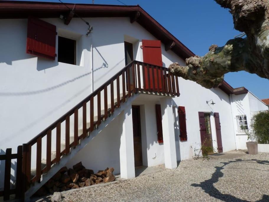 una casa blanca con una escalera delante en T3 PAYS BASQUE SUD LANDES, en Tarnos